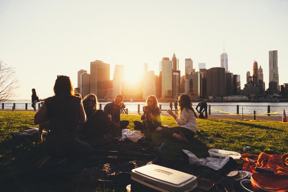 friends enjoying sunset picnic in the city